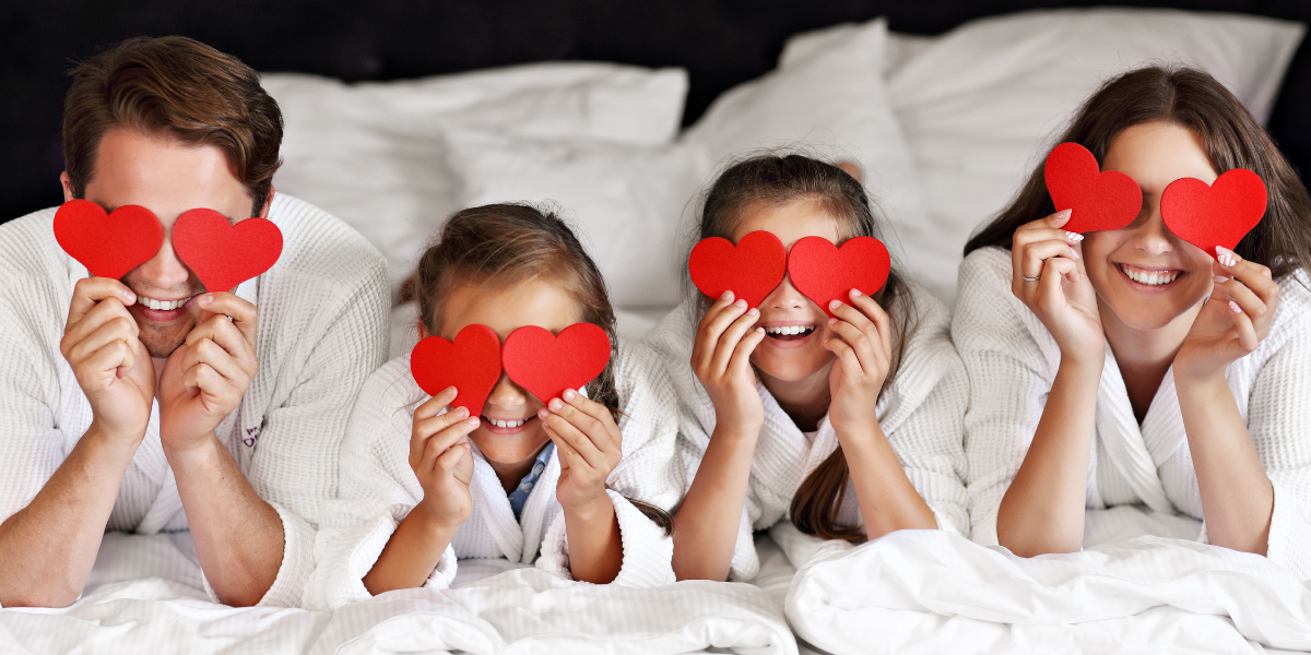 A cheerful family gathered in a cozy bedroom, celebrating Valentine's Day with festive crafts and heartfelt moments. This image highlights family bonding and creative ways to enjoy Valentine's Day together.