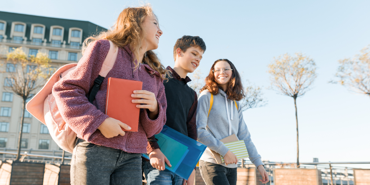 High school students laughing and having fun on their way home, showing how overcoming back-to-school anxiety leads to positive experiences and friendships.