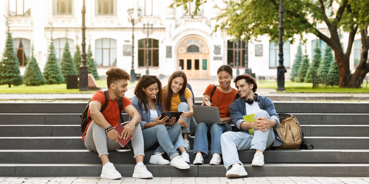 A group of young students gathered on a university campus, discussing the benefits of open university programs and flexible learning.