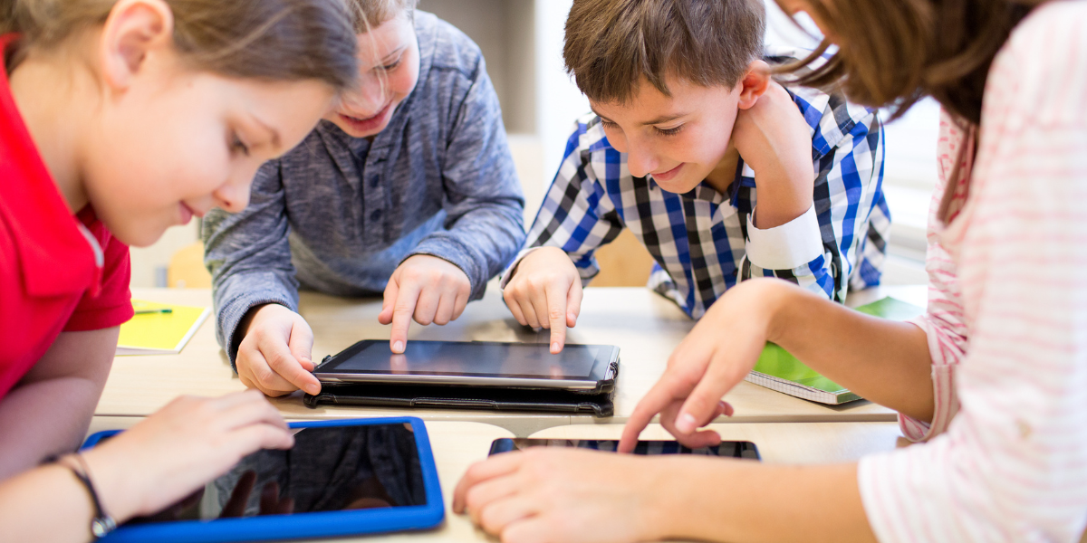 Kids using modern school supplies like tablets, notebooks, and colorful stationery, highlighting how classroom tools have evolved over time.