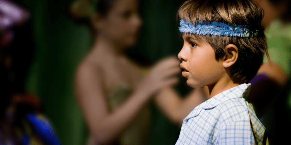 A young child expressing emotion while performing in a reader’s theatre, highlighting the power of reading activities in developing confidence and reading fluency.